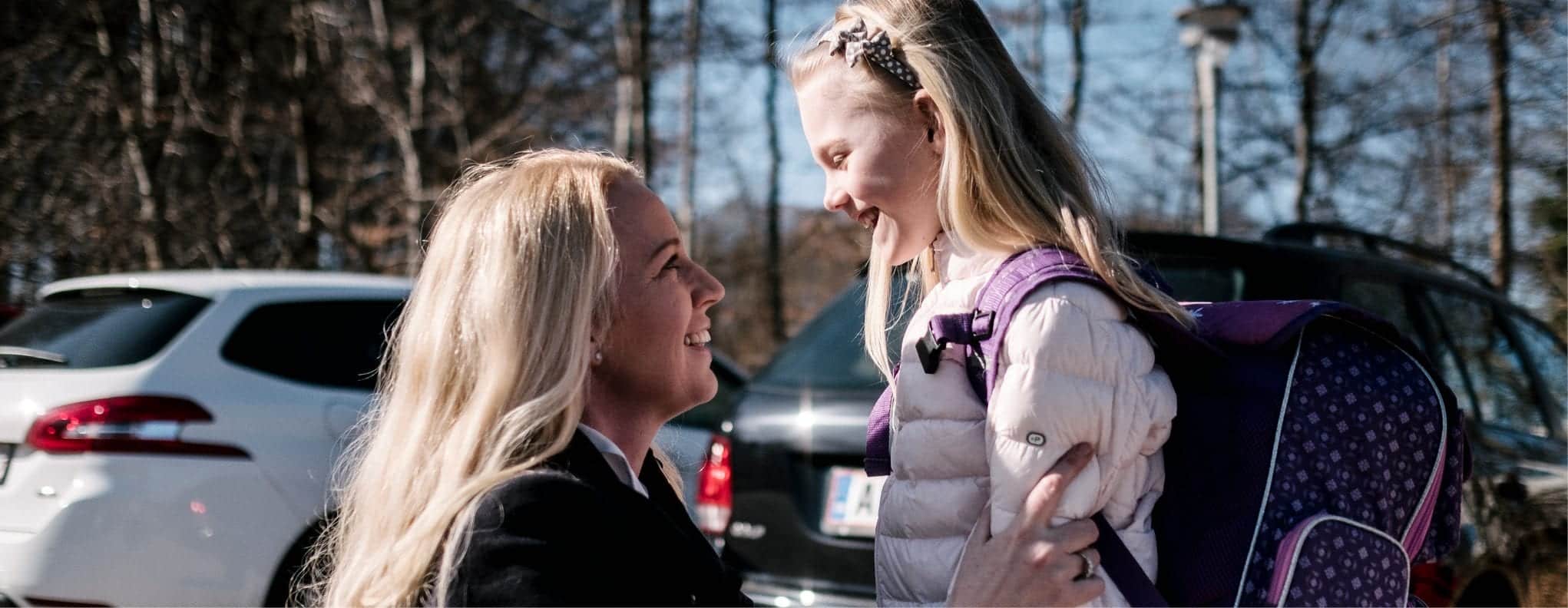 En mor siger farvel til sin datter, som er på vej i skole.